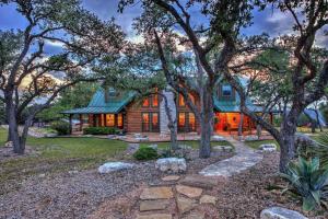 a log home with a green roof and trees at Outdoor Adventure Experience - Camp David Retreat in Dripping Springs