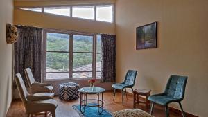 una sala de espera con sillas, una mesa y una ventana en Fruitsnbeans Homestay Kodaikanal, en Kodaikanal