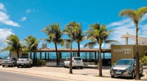 a parking lot with palm trees in front of a building at Apartamento Pé na Areia - Ótima Localização - Conforto à beira-mar in Ilhéus
