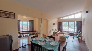 una sala de estar con una mesa y sillas en Fruitsnbeans Homestay Kodaikanal, en Kodaikanal 15 fotos más
