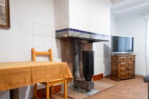 Cette chambre dispose d'une cheminée, d'une table et d'une télévision. dans l'établissement Elrubiorural Casa el rubio Corcolilla, à Corcolilla