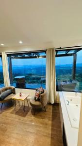 Una sala de estar con un gran ventanal con vistas. en Ninho da Águia - Cabana A, en Urubici 14 fotos más