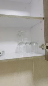 a row of wine glasses sitting on a shelf at Nala Realty at The Aura in Sandton