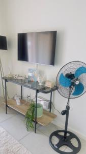 a desk with a fan and a television on a wall at Nala Realty at The Aura in Sandton