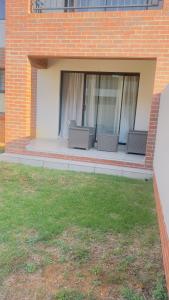 a patio with two chairs on a brick building at Nala Realty at The Aura in Sandton