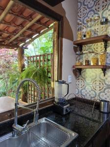 a kitchen counter with a sink and a window at Loft nas Montanhas! in Nova Lima