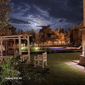 a backyard at night with a pergola and a pool at Casa linda con pileta y parque in San Pedro
