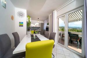 a dining room with a table and yellow chairs at Apartment Kampor 1 in Kampor