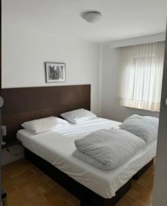 ein Bett mit weißer Bettwäsche und Kissen in einem Schlafzimmer in der Unterkunft Zum Griechen Restaurant und Pension in Forchtenberg + 12 Fotos