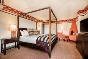a bedroom with a canopy bed and a television at Inn & Spa at Loretto in Santa Fe