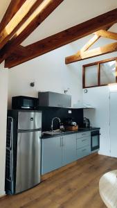 a kitchen with stainless steel appliances and a wooden floor at Loulo 'dge in Saint-Donan