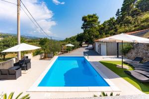 a swimming pool in a yard with umbrellas at Apartment Kampor 1 in Kampor
