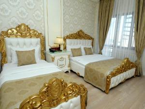 two beds in a hotel room with gold furniture at Best Town Hotel in Istanbul