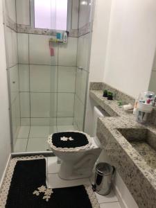 ein Bad mit einem WC und einer Glasdusche in der Unterkunft Vivendas do Rio 1 in Ananindeua
