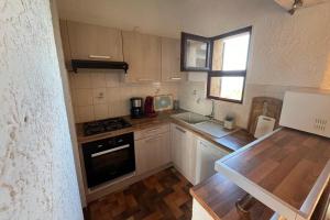 a small kitchen with white cabinets and a window at Appartement en bord de mer Marine de Sant-Ambrogio in Lumio +6 photos