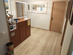 an empty room with a wooden floor and a door at Hostal Álvarez in Oviedo