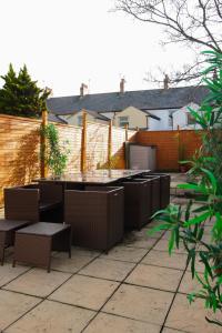 eine Terrasse mit Tischen und Stühlen und einem Zaun in der Unterkunft House near Cardiff City Centre in Cardiff