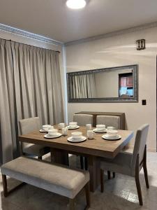 a dining room table with chairs and a mirror at La casa de Carmen- Moderno apartamento in Ezequiel Montes