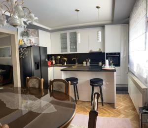 a kitchen with a table and a black refrigerator at Kuća za odmor ''ANA'' in Čitluk