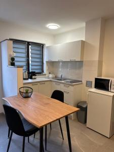 a kitchen with a wooden table and a table and chairs at Apartment Bilić in Pula