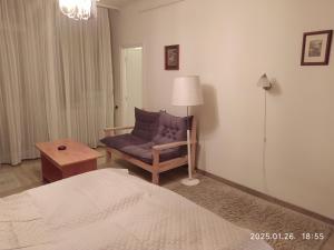 a bedroom with a bed and a chair and a lamp at 4 turtles apartman in Budapest