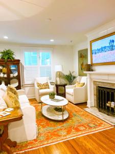 a living room with white furniture and a fireplace at The Eakes House on South 8th in Oxford