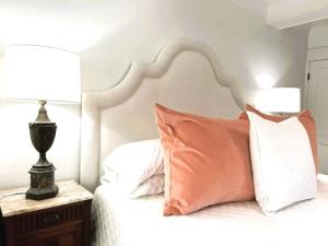 a bed with a pink pillow and a lamp on a table at The Eakes House on South 8th in Oxford +36 photos