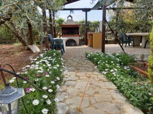 a garden with a stone pathway and flowers at Ground beach studio in Nea Potidaea