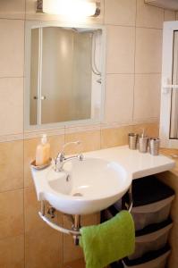 a bathroom with a sink and a green chair at Apartments AstaLaVIsta in Okrug Donji +27 photos