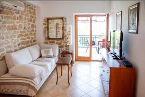 a living room with a couch and a television at Apartments AstaLaVIsta in Okrug Donji