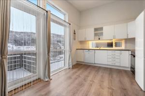 DørheimにあるGuesthouse-Ølen, 2 bedroomの白いキャビネットと大きな窓付きの広いキッチン