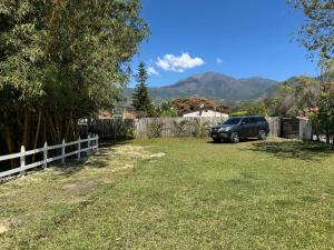 un coche aparcado en un patio junto a una valla en Hermosa cabaña amoblada en Pueblo Bello, Sierra Nevada, en Pueblo Bello