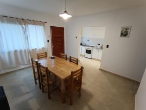 a dining room with a wooden table and chairs at Aloha 2 in Chacabuco
