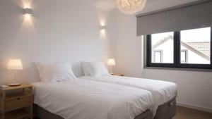 Un dormitorio con una cama con sábanas blancas y una ventana. en Maçãs Home-Sky sea view at The Beach, en Colares 52 fotos más