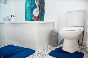a bathroom with a white toilet and blue rugs at 5 bedroom house near cardiff city. in Cardiff +32 photos