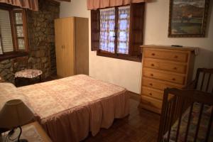 Schlafzimmer mit einem Bett, einer Kommode und einem Fenster in der Unterkunft Vivienda Quintana in La Cueva