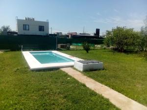 a swimming pool in the grass in a yard at Capibara Matero in Roldán +6 photos