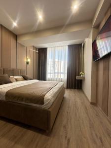 a bedroom with a large bed and a large window at Privat Apartment Ciocana in Chişinău