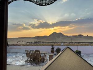 une table et des chaises sur un balcon avec vue sur une montagne dans l'établissement Seror Guest House, au Caire