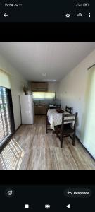 a room with a kitchen with a table and a refrigerator at Las andinas in Carmelo