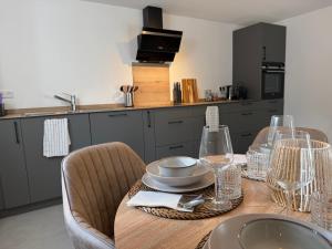 a kitchen with a wooden table with plates and wine glasses at Direkt am Marktplatz - Freudenstadt und Schwarzwald erleben in Freudenstadt