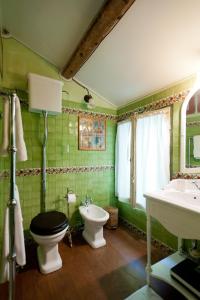a green bathroom with a toilet and a sink at Casa Delle Meridiane in Ravenna