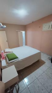 a bedroom with a large white bed and a table at Casa temporada, férias e final de semana in Viçosa do Ceará