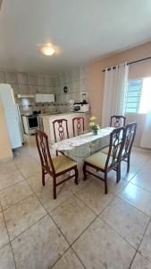 a kitchen with a table and four chairs and a table and a kitchen at Casa temporada, férias e final de semana in Viçosa do Ceará