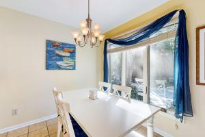 a dining room with a white table and chairs and a window at Turtle Cove 4849 in Kiawah Island