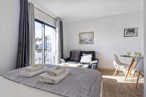 - une chambre blanche avec un lit et 2 serviettes dans l'établissement Forum Ocean View 4B by Homie, à Funchal