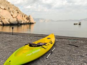 een gele kajak op een strand naast het water bij Overnight Musandam 20 tents whole Private camp for groups bathroom and kitchen in Al Frian