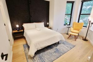Un dormitorio con una cama blanca y una silla amarilla. en Contemporary Home in Shaw-U Street, en Washington