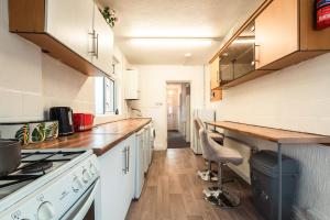 Una cocina con gabinetes blancos y una encimera de madera. en 6 beds in 4 bedrooms house, en Southampton