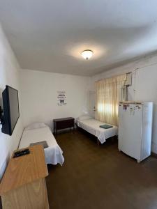 una camera ospedaliera con due letti e un frigorifero di Los Lirios Gardes Pehuajo a Pehuajó